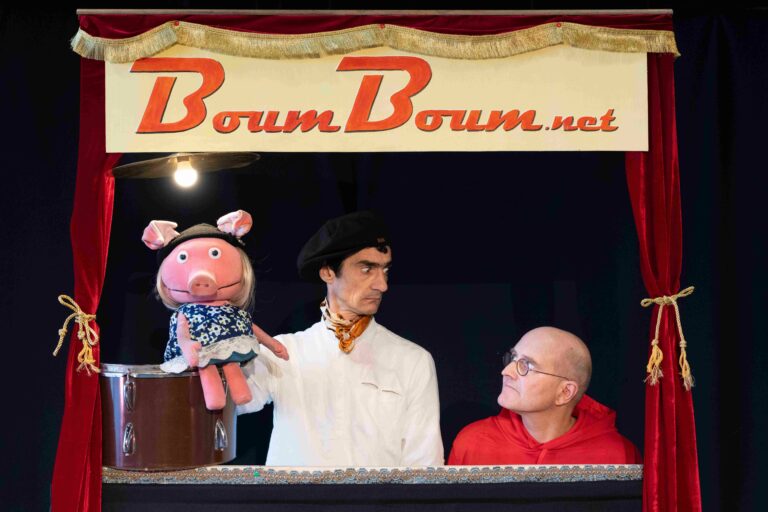 photo de spectacle avec une marionnette et deux comédiens dans leur castelet